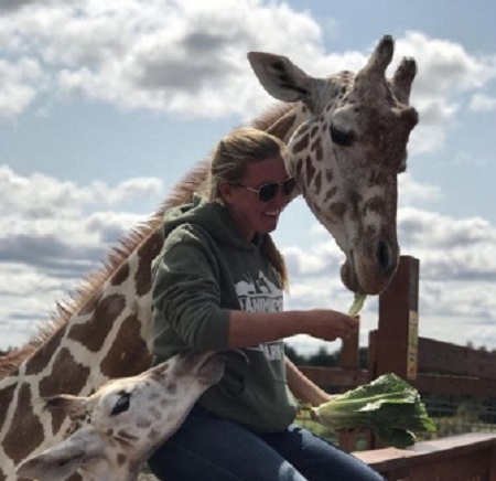 Allysa Swilley's feeding an Girafee April and her son Tajiri at Animal Adventure Park 